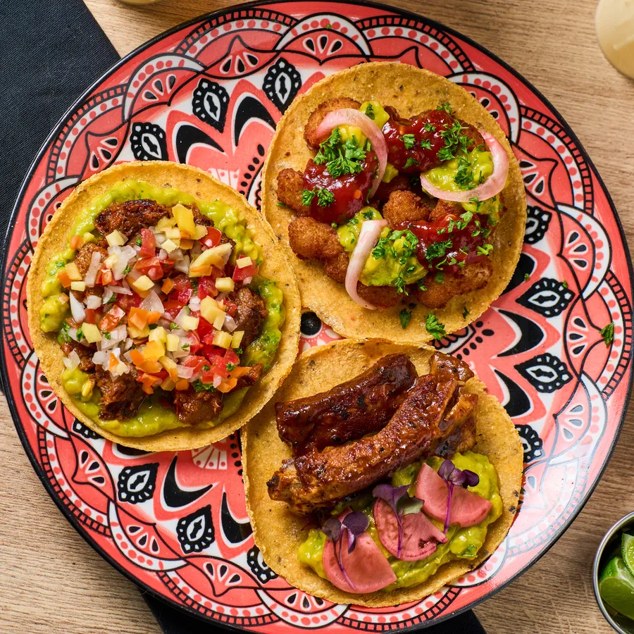 Tacos de birria, pastor y cochinita en plato de talavera
